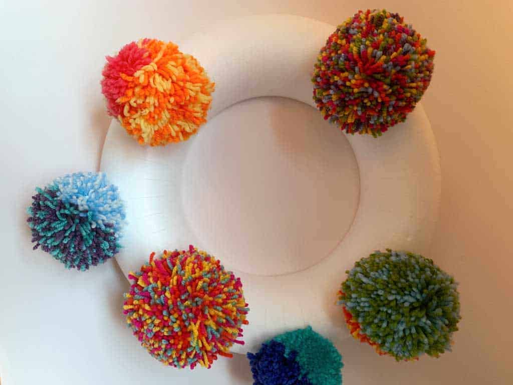 Want to learn how to make a pom pom wreath? This is such a fun project!